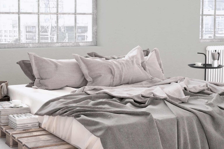 Slaapkamer met bed, kussens en sprei