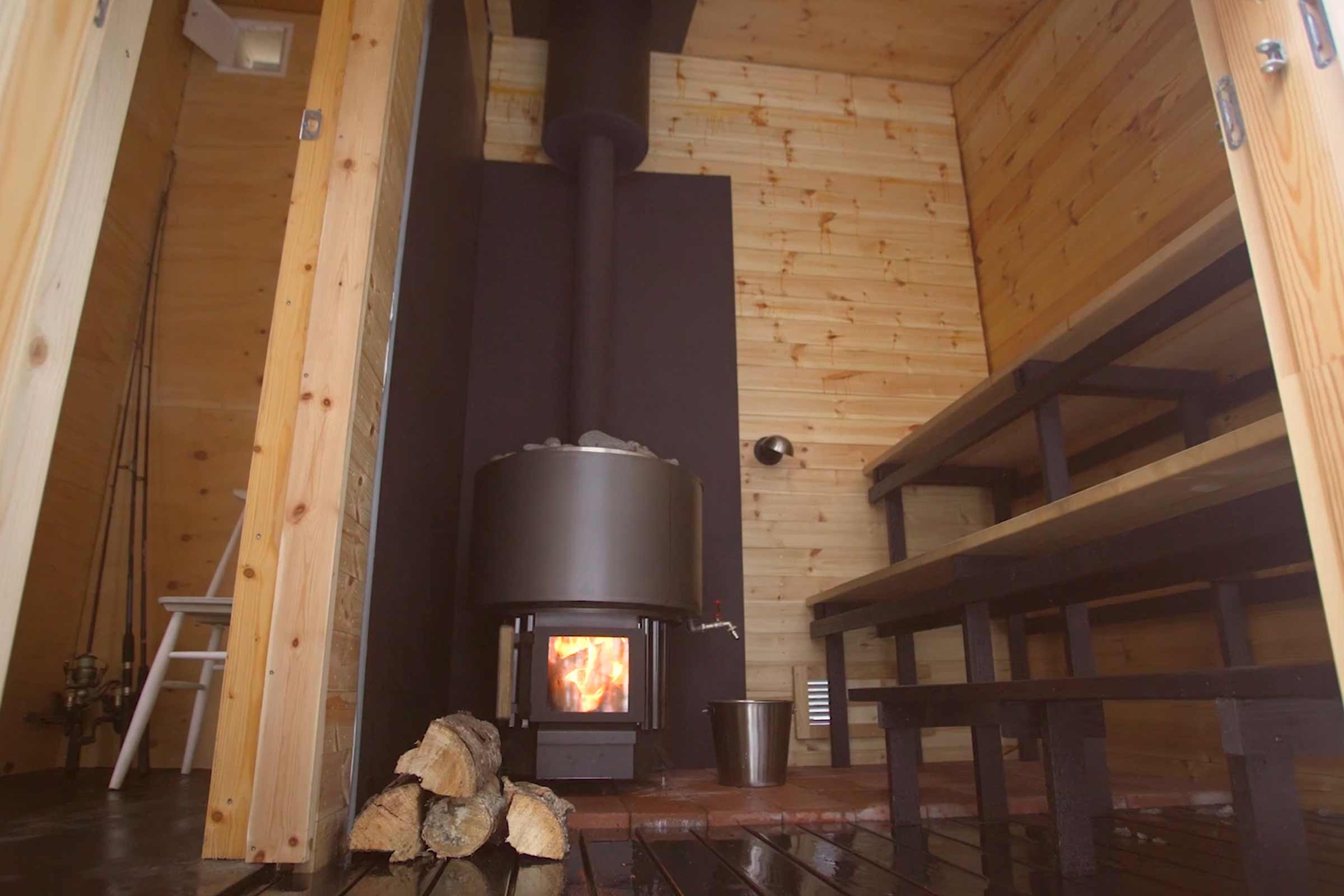 Houten sauna met houtkachel en saunabanken