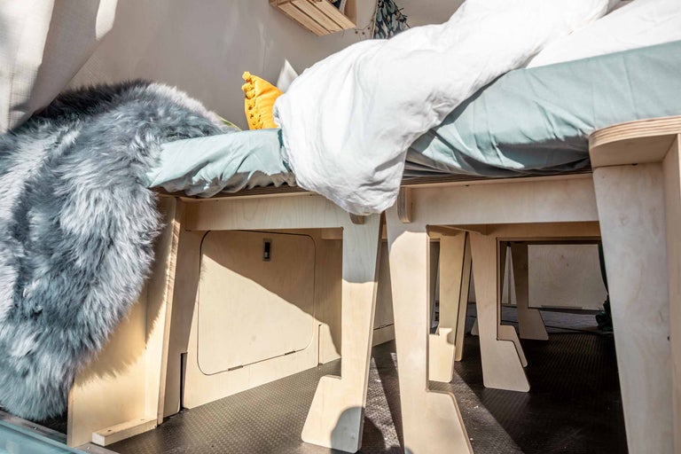 Interieur van een transportwagen met een houten bedframe