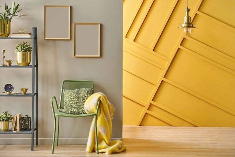 Decoratieve woonkamer met rekken, stoel, kussen, deken en wanddecoratie