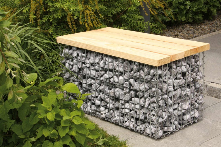 Gabionenbank met houten blad in de tuin