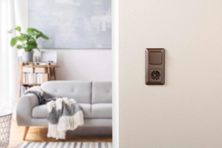 Bruin stopcontact met schakelaar in een woonkamer