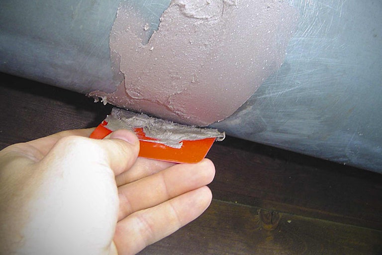 Aanbrengen van afdichtmiddel met een plamuurmes op een buis