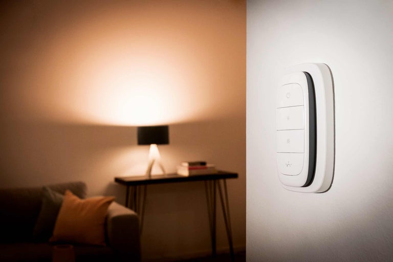 Slimme wandschakelaar voor lichtregeling in een woonkamer.