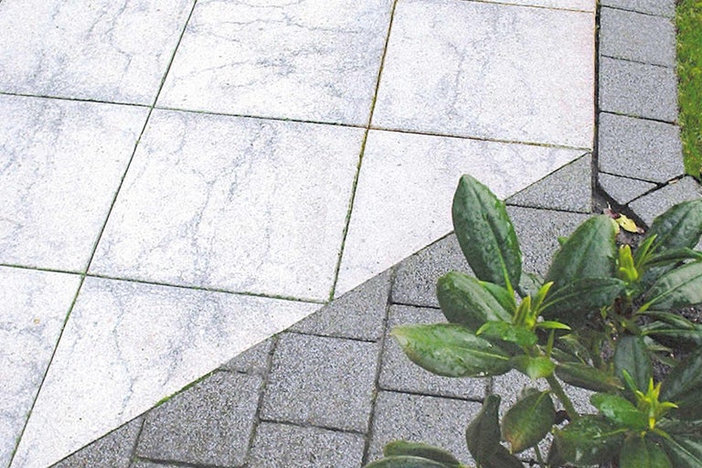 Terras met lichtgrijze betontegels en donkergrijze bestrating