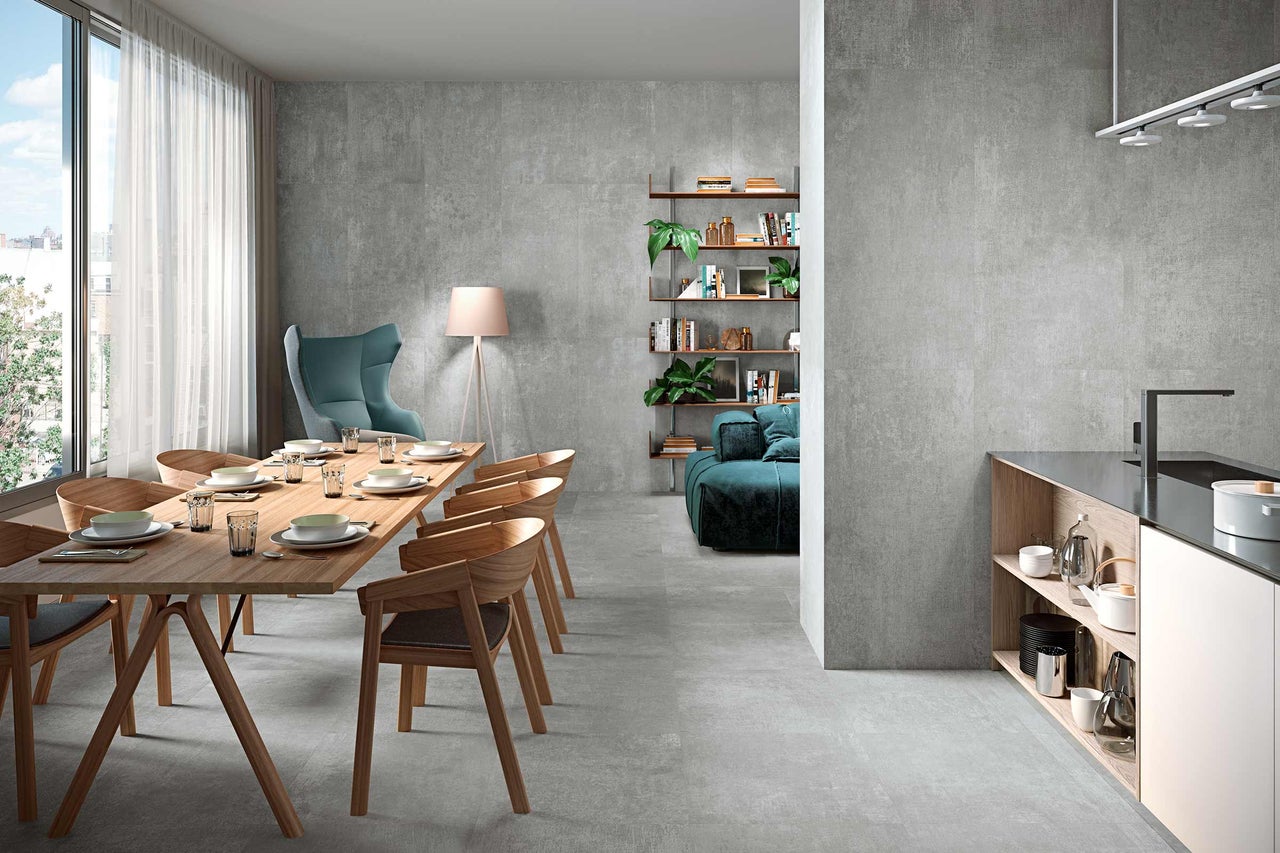 Interieur met eettafel, stoelen, planken en grijze keramische tegelvloer.