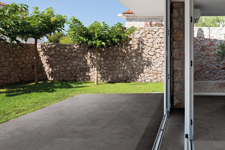 Terras met stenen muur, bomen en vloertegels