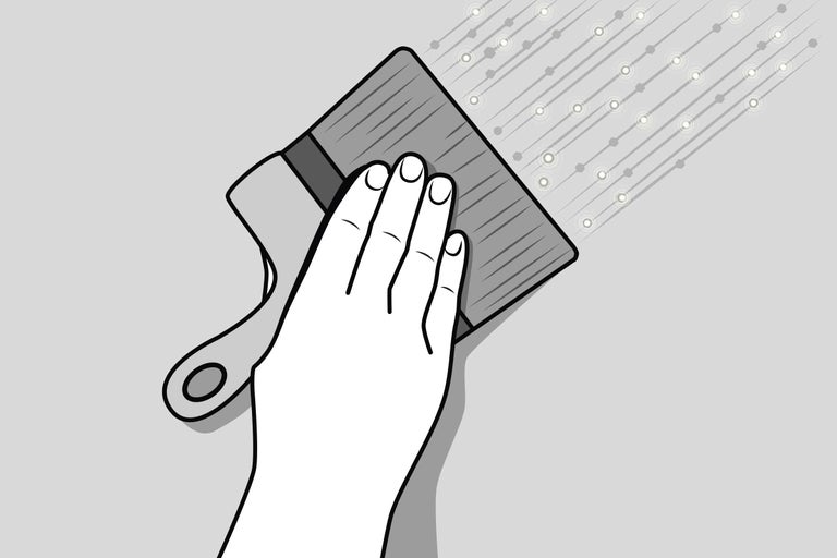 Een hand houdt een borstel vast tijdens het aanbrengen van verf op een oppervlak