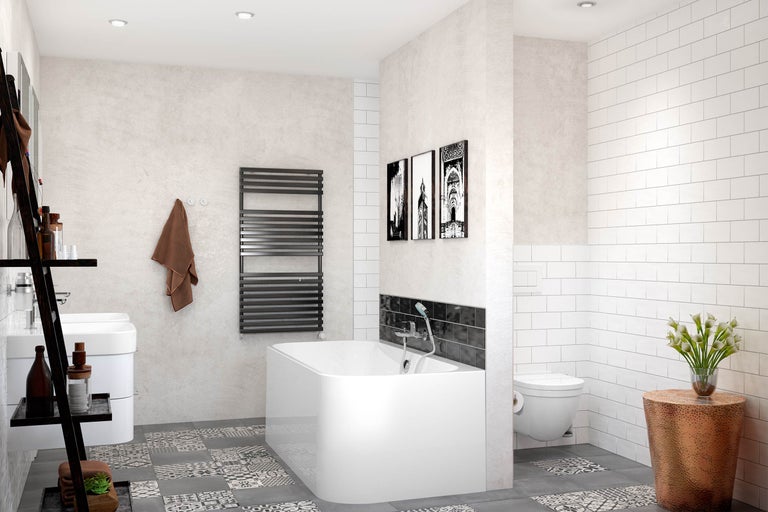 Moderne badkamer met bad, handdoekradiator, wastafel, toilet en decoratieve elementen.