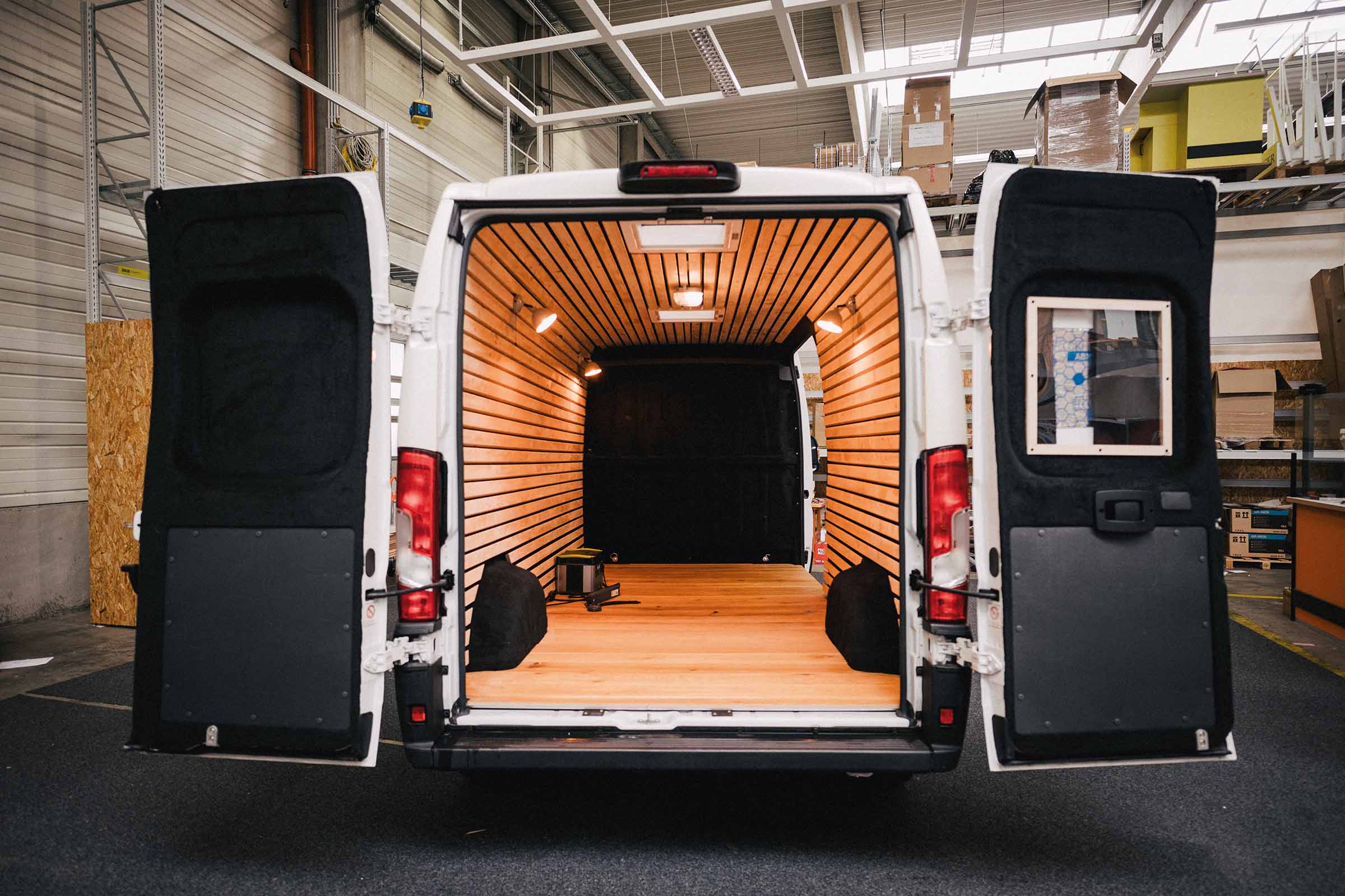 Interieur van een bestelwagen met houten bekleding en open achterdeuren