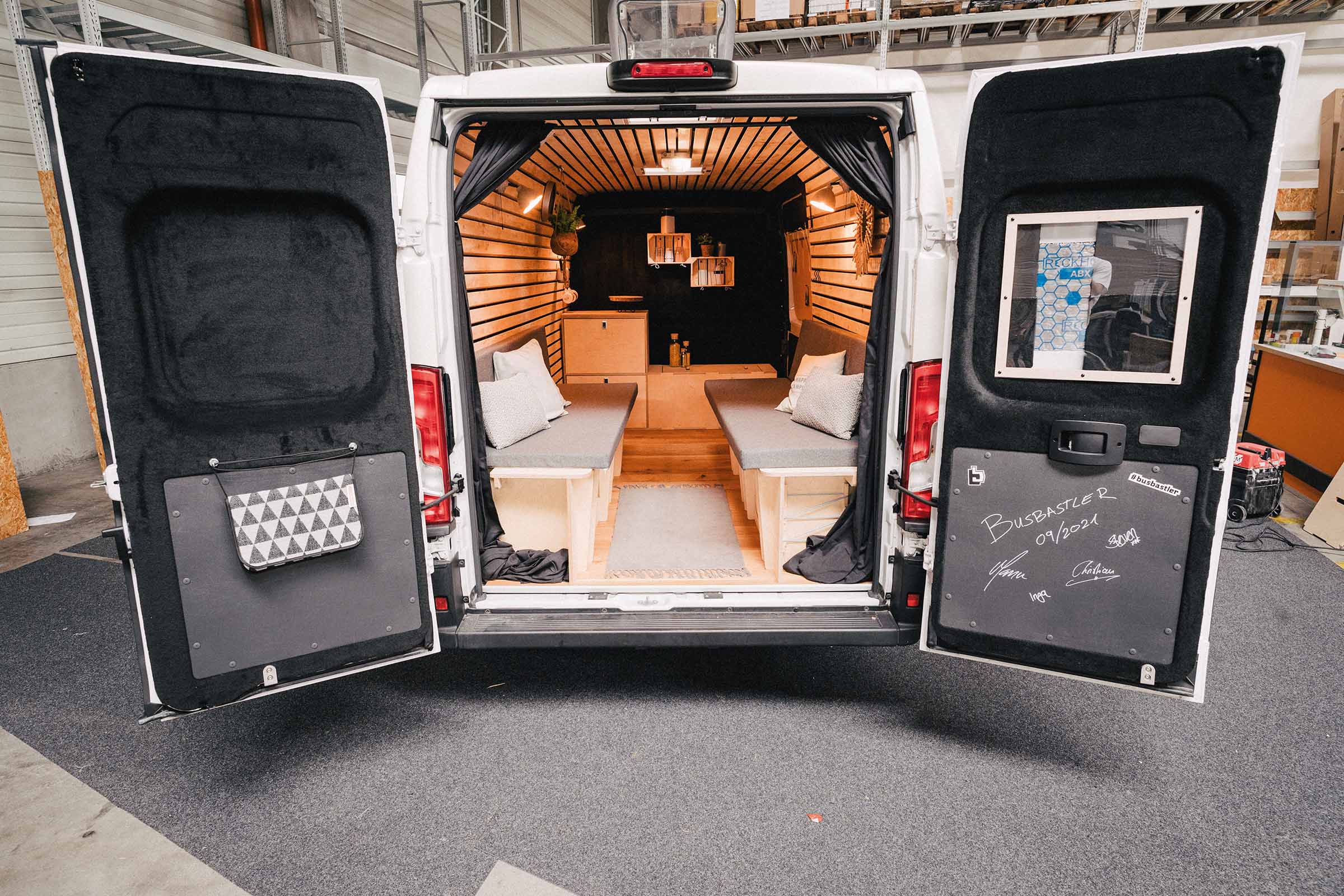 Interieur van een omgebouwde bestelwagen met houten inrichting en zitplaatsen