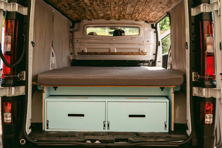 Omgebouwde bestelwagen met bed en lades voor kampeertrips