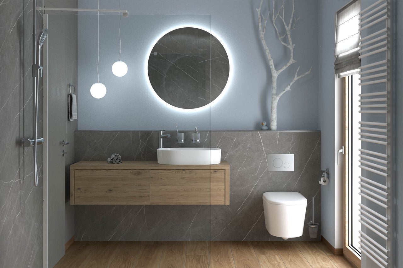 Moderne badkamer met houten wastafelonderkast, ronde spiegel met ledverlichting, opzetwastafel, hangend toilet en douche.