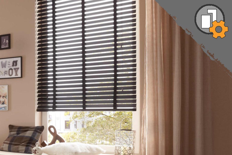 Kamer met zwarte jaloezieën en gordijnen voor het raam.