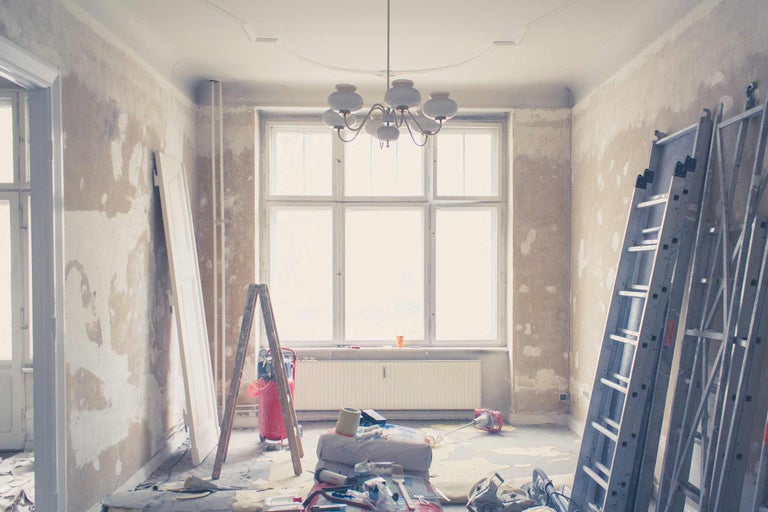 Renovatiescène met ladder, deur en renovatiegereedschap in een kamer