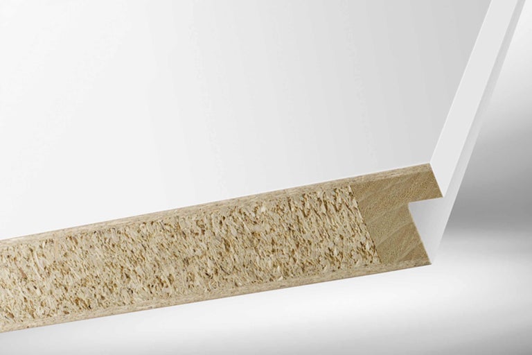 Close-up van een wit gecoate spaanplaat die de houtspanenstructuur laat zien