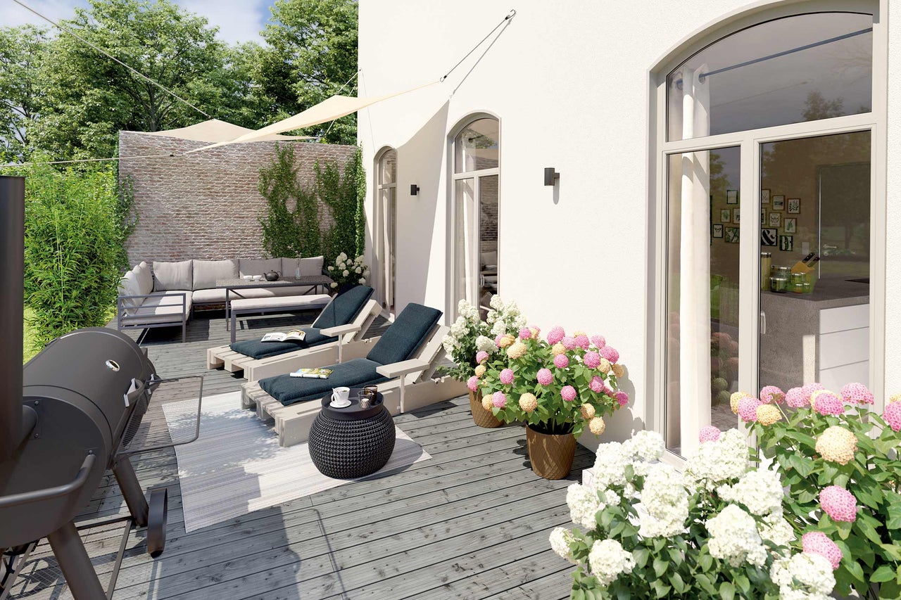 Buitenkant met barbecue, tuinmeubelen, zonnescherm en bloeiende planten op een houten terras