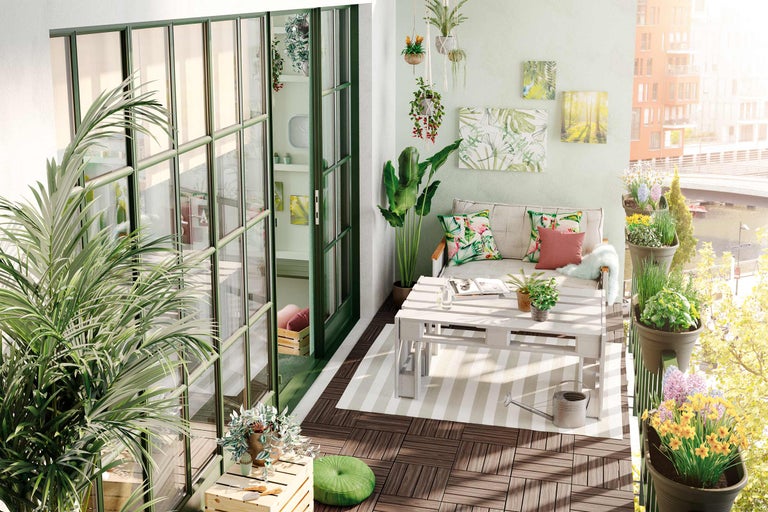 Gedecoreerd balkon met meubels, planten en houten vloertegels.