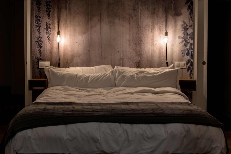 Slaapkamer met tweepersoonsbed, nachtkastjes en wandlampen