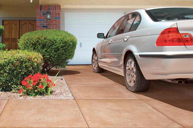 Oprit met bestrating, garage en auto