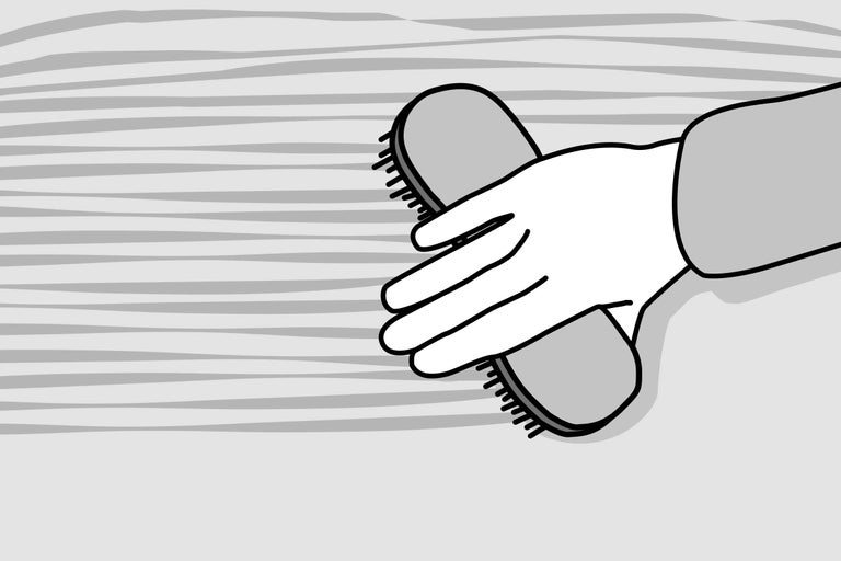 Hand met borstel voor het reinigen van oppervlakken