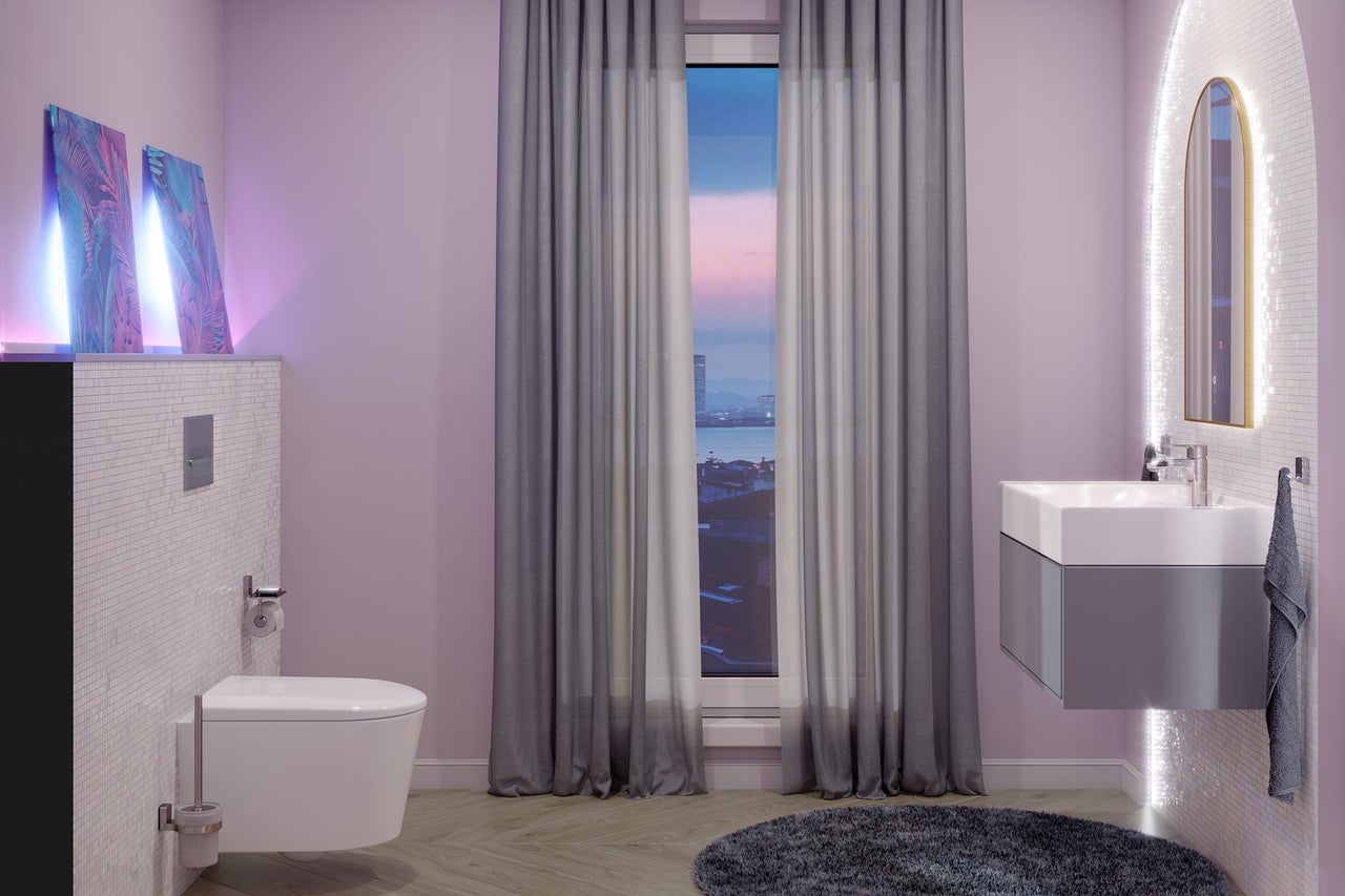 Moderne badkamer met hangend toilet, wastafelmeubel, verlichte spiegel en raam met gordijnen.