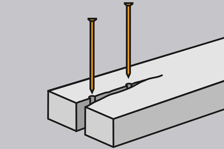 Twee spijkers in een stuk hout
