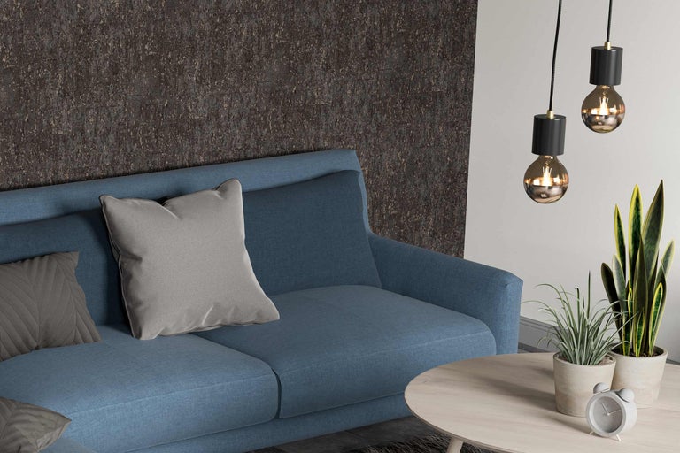 Woonkamer met blauwe bank, kussens, salontafel, kamerplanten en hanglampen