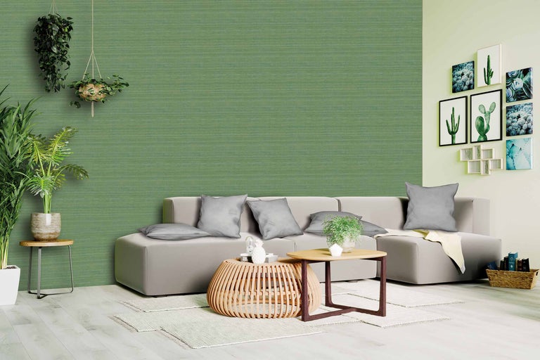 Woonkamer met groen wandbehang, bank en salontafels