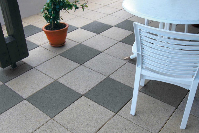 Terras met terrastegels in schaakbordpatroon, tafel, stoel en potplant