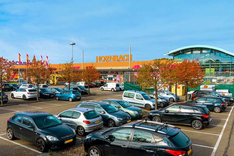 Hornbach bouwmarktgebouw met parkeerplaats en veel geparkeerde auto's