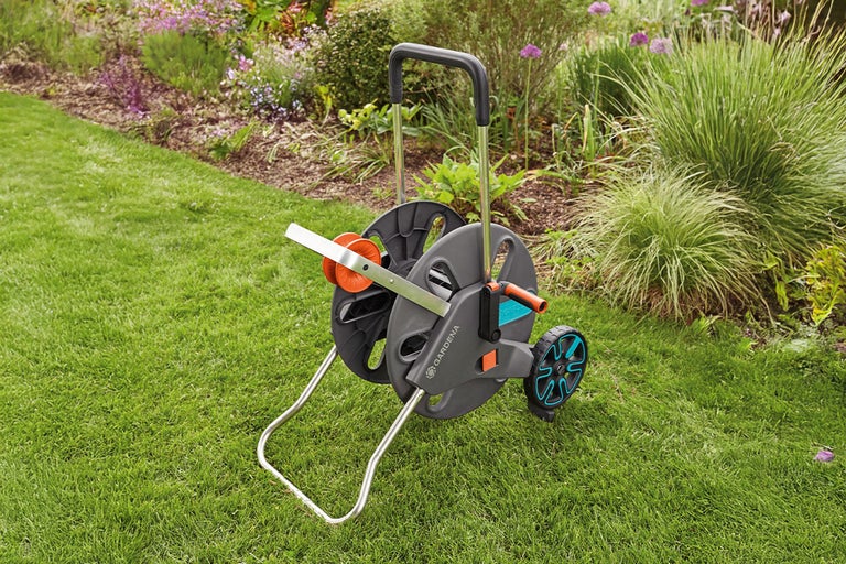 Gardena tuinslangwagen op gazon voor bloembed