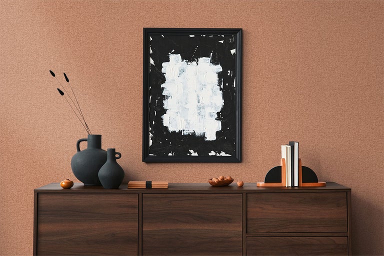 Woonkamer met dressoir, vazen, boekensteunen en een ingelijst abstract schilderij