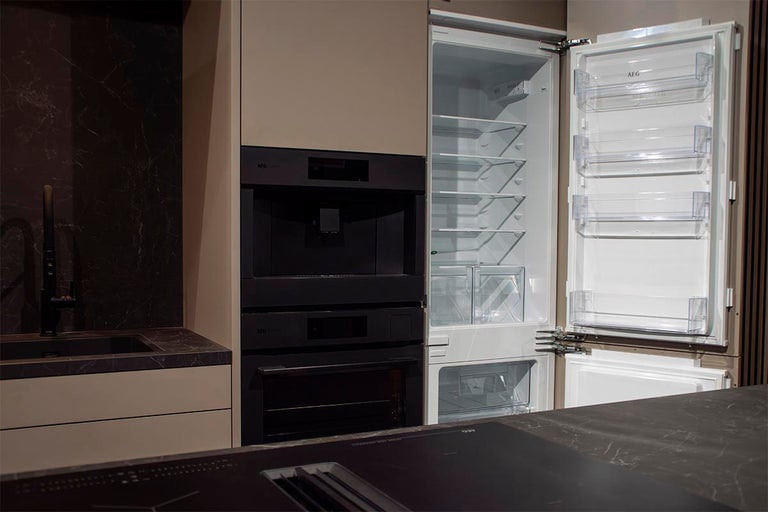 Moderne keuken met ingebouwde koelkast, koffiemachine en oven