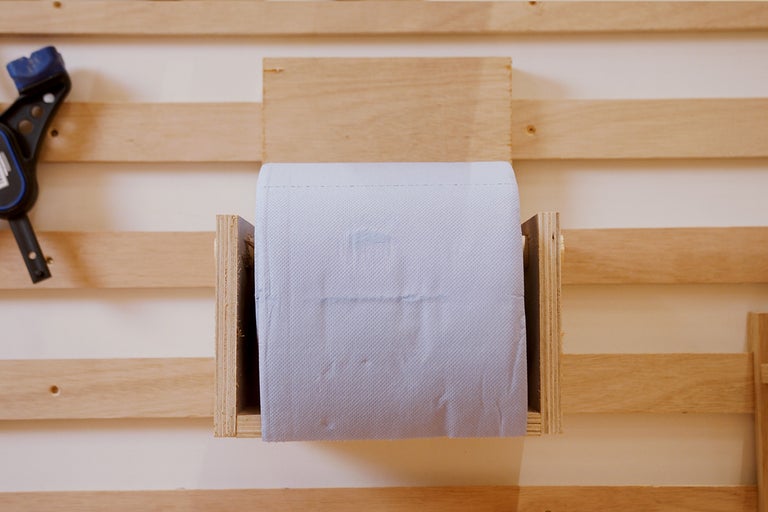 Houten toiletpapierhouder met een rol toiletpapier