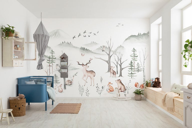 Lichte kinderkamer met bosbehang, ledikant, hemelbed en houten vloer.