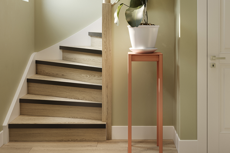 Traprenovatie met treden in houtlook en donkere randprofielen in een lichte, modern ingerichte hal.