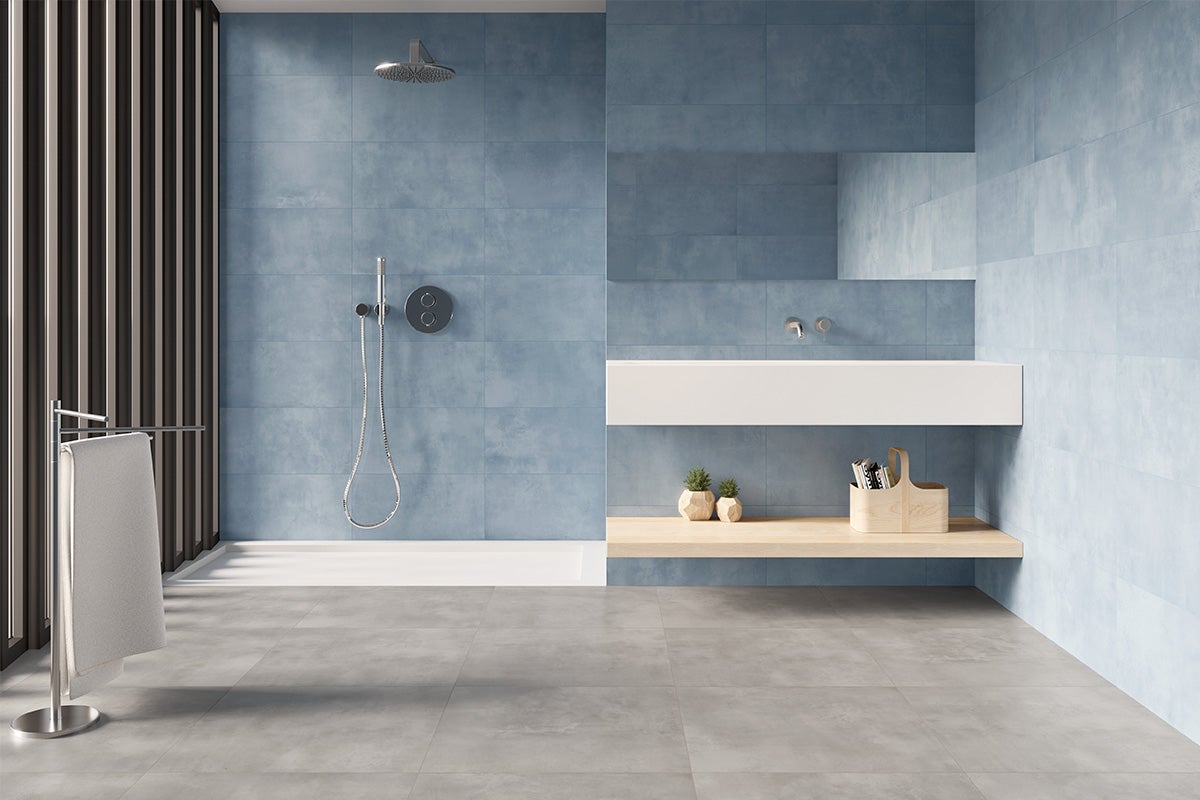 Moderne badkamer met blauwe tegels, douche, wastafel en handdoekrek