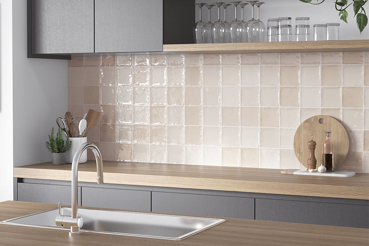 Keukenscène met betegelde wand, gootsteen en keukengerei.