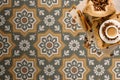 Decoratieve vloertegels met bloemmotief en koffiearrangement. Decoratieve vloertegels met bloemmotief en koffiearrangement.