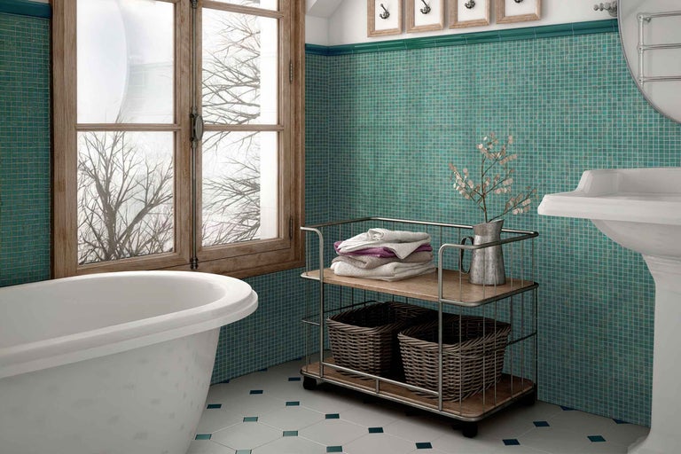 Badkamer met ligbad, wastafel, opbergwagen en mozaïektegels op de wand