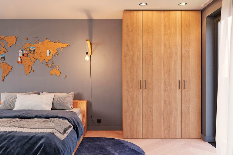 Slaapkamer met tweepersoonsbed, wereldkaart van kurk aan de muur en grote houten kast