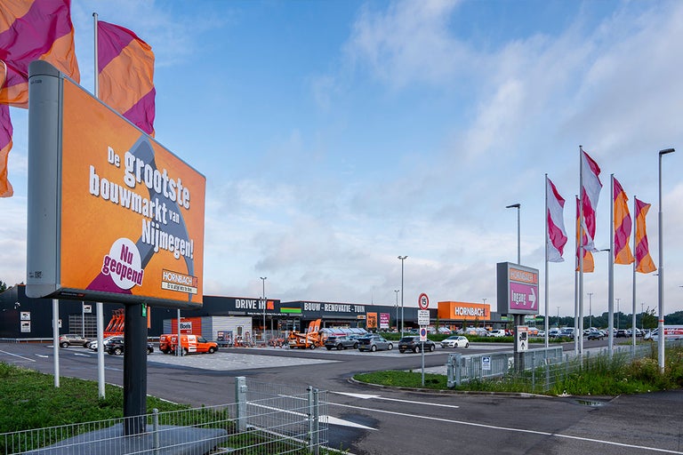 Buitenaanzicht van de Hornbach bouwmarkt met bewegwijzering en parkeerplaats