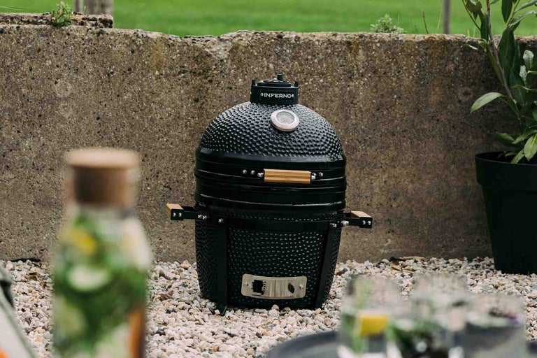 Zwarte keramische barbecue in de tuin.