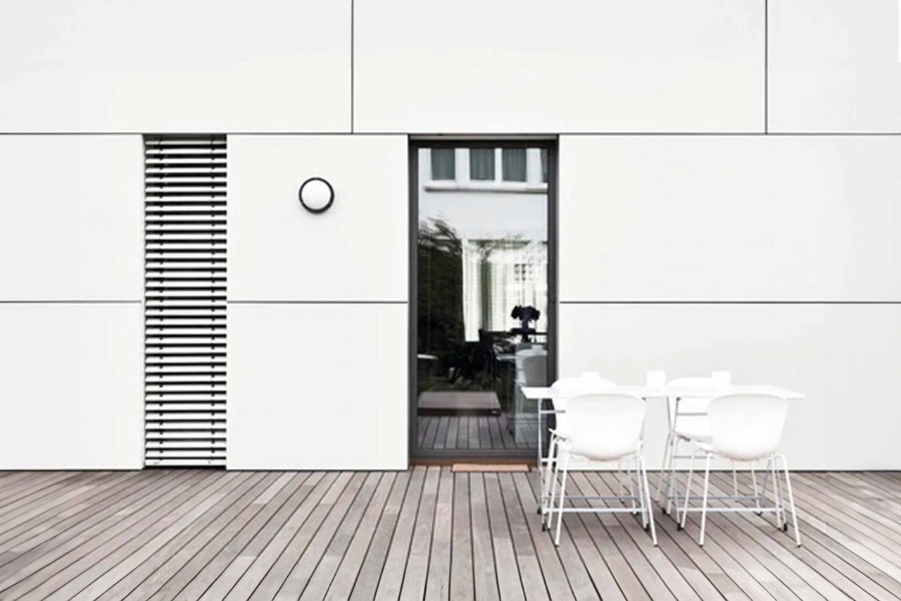 Terras met houten vloer, tuinmeubelen en gevel