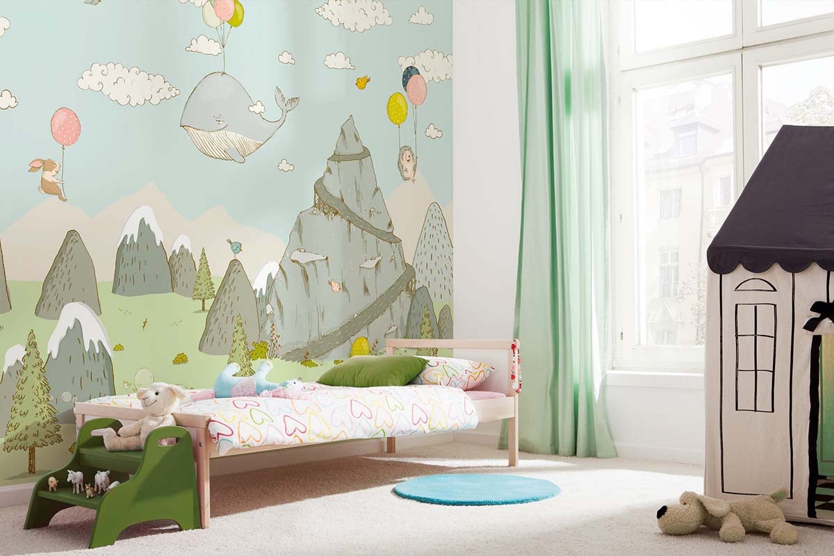 Kinderkamer met fotobehang met bergen en vliegende dieren in een lichte inrichting.