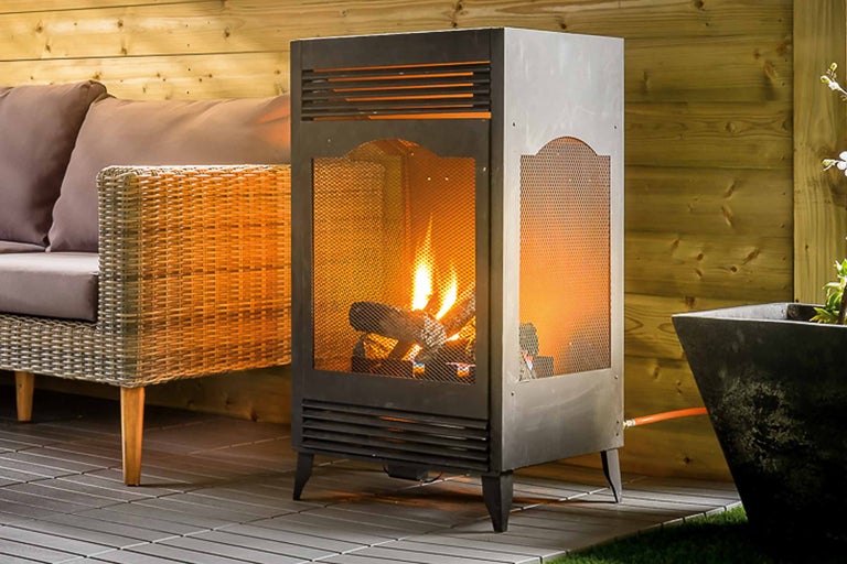 Terrasscène met gaskachel, rotanbank en plantenbak.