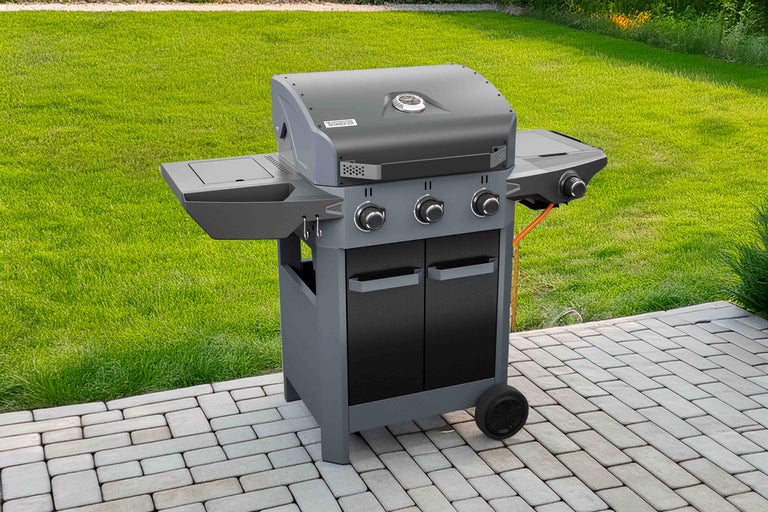 Tenneker gasbarbecue met drie branders, bijzettafel en onderkast op een terras