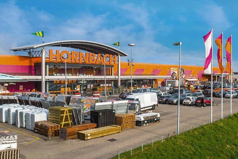 Buitenaanzicht van een Hornbach bouwmarkt met parkeerplaats en goederenassortiment