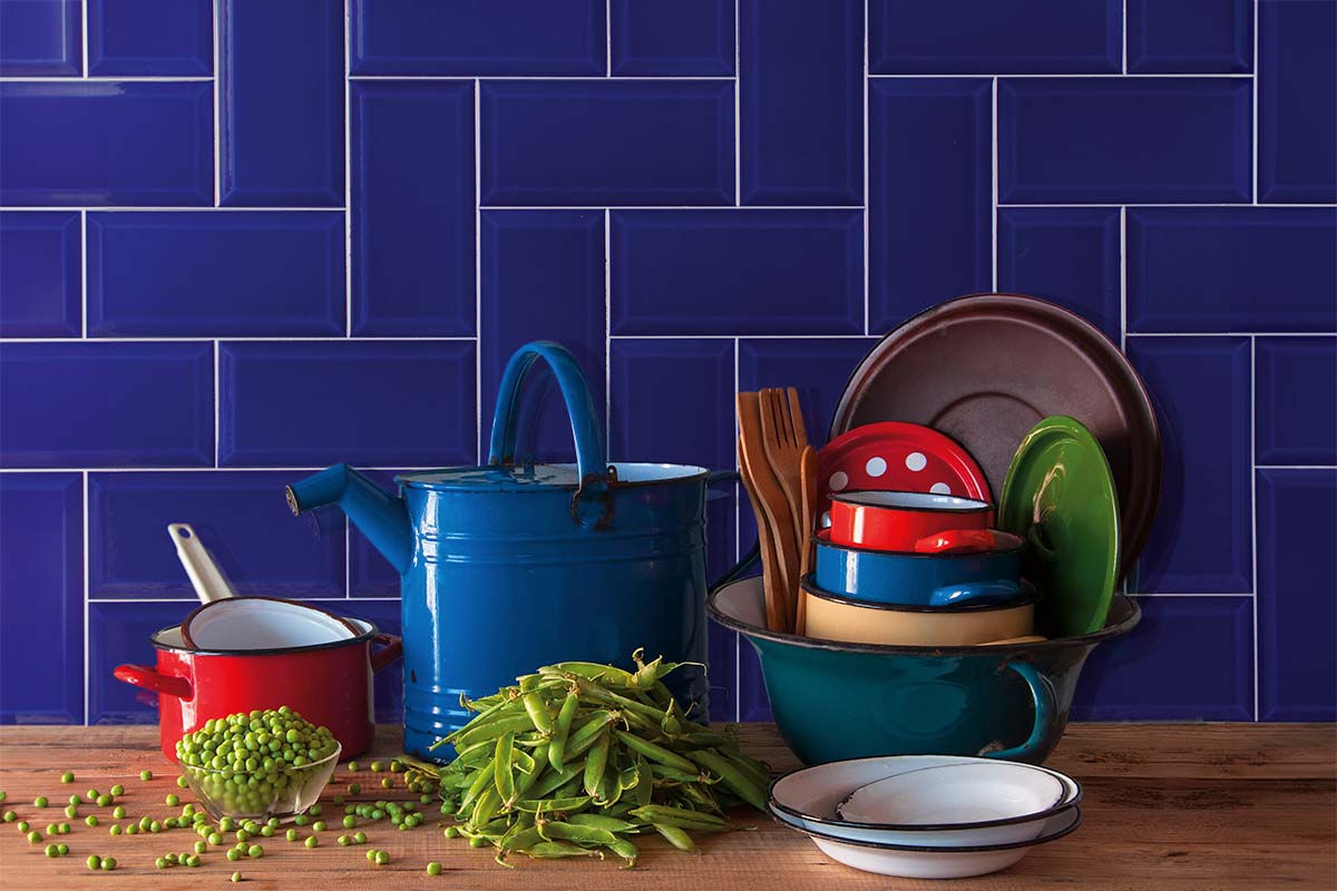 Keukenscène met blauwe tegels, kookgerei en erwten op een houten tafel